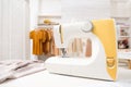 Modern sewing machine, fabric and accessories in dressmaking workshop Royalty Free Stock Photo