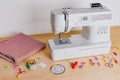 A Modern Sewing Machine with Fabric, Tools, and Supplies for Creative Crafting and Tailoring Projects on a Wooden Table Royalty Free Stock Photo