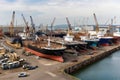 modern shipyard filled with a variety of ships in different stages of construction