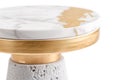 A modern side table sits on a plain background. The table features a marble top with a gold accent and a solid base. This piece Royalty Free Stock Photo