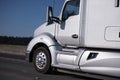 Modern silver big rig semi truck driving by interstate highway Royalty Free Stock Photo