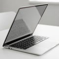 Modern Silver Laptop with Keyboard and Screen Reflected on White Table computer technology Royalty Free Stock Photo