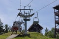 Modern ski lift cable car system with technical tower and support infrastructure on green summer slope under clear blue sky Royalty Free Stock Photo