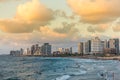 Modern skylines and luxury hotels under twilight at the beach near the old city Jaffa in Tel Aviv, and lots of tourists and locals