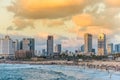 Modern skylines and luxury hotels under twilight at the beach near the old city Jaffa in Tel Aviv, and lots of tourists and locals