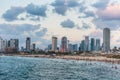 Modern skylines and luxury hotels under twilight at the beach near the old city Jaffa in Tel Aviv, and lots of tourists and locals