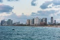 Modern skylines and luxury hotels under twilight at the beach near the old city Jaffa in Tel Aviv, and lots of tourists and locals