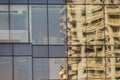 Modern Skyscraper Building With Glass Reflecting The Workers In Construction Site. Abstract Reflection Of The Office Building With