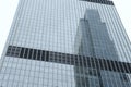 Modern skyscraper with glass windows. From below of contemporary tall building with reflection of skyscraper. Royalty Free Stock Photo