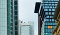 Modern skyscrapers with strict rectangularly patterned glass facades behind an old historic brown sandstone building Royalty Free Stock Photo