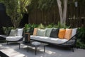 modern, sleek patio furniture with cushioned seats and vibrant accent pillows against a lush garden Royalty Free Stock Photo