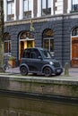 Modern small electric car Amsterdam in front of Hash Marihuana Museum