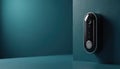 Modern smart doorbell camera hangs on dark teal wall. Sleek electronic security device features digital lens, illuminated ring Royalty Free Stock Photo