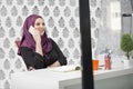 Modern smart female Islamic office worker talking on phone