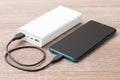 Modern smart phone charging with help of big power bank Royalty Free Stock Photo