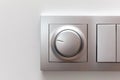 Modern smart rotary knob light dimmer light switch mounted on a wall, front view, frontal shot, object detail closeup. Dimming
