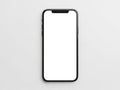 Modern smartphone with a blank white screen isolated on a light gray background, top view Royalty Free Stock Photo