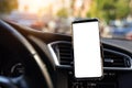 Modern smartphone device gadget mounted on phone holder at car dashboard. Mock-up white screen isolated template. Copyspace for