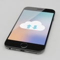 Modern smartphone displaying cloud computing icon with upload arrows on blurred abstract background Royalty Free Stock Photo