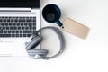 Modern smartphone, gray headphones, a gray laptop and a blue mug isolated on a white background Royalty Free Stock Photo