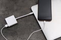 Modern smartphone and laptop charging from power bank on grey table, above view Royalty Free Stock Photo