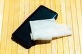 Modern smartphone and a wet wipe, damp tissue on the table Mobile phone disinfecting, cleaning, sanitizing, technology and hygiene Royalty Free Stock Photo