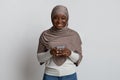 Modern Black Islamic Woman In Hijab Using Smartphone And Smiling At Camera Royalty Free Stock Photo