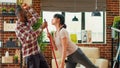 Modern smiling couple dancing and cleaning apartment Royalty Free Stock Photo