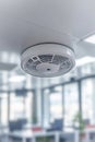 Modern Smoke Detector Installed on Clean Ceiling in Brightly Lit Contemporary Office Environment Royalty Free Stock Photo