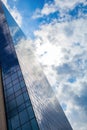 Modern smoked glass office building against a blue cloudy sky. Royalty Free Stock Photo