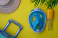 Modern snorkeling mask, palm tree branch, turquoise suitcase and stylish boater hat on a yellow background. Summer time and travel Royalty Free Stock Photo