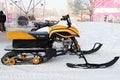 Modern snowmobile stands near the ice town on the street of the