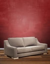 Modern sofa against textured red wall Royalty Free Stock Photo