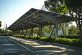 A modern solar carport for public vehicle parking is outfitted with solar panels producing renewable energy. Generative AI Royalty Free Stock Photo