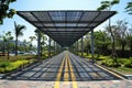 A modern solar carport for public vehicle parking is outfitted with solar panels producing renewable energy. Generative AI