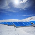 Modern solar station with blue panels standing in winter field w