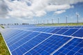 Modern solar station with blue panels and windfarm with wind tur Royalty Free Stock Photo