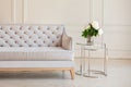 Modern Spacious minimalistic living room interior with a gray sofa and a coffee table with a vase with a bouquet of peonies flower