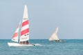 Modern sport catamaran and traditional wooden dhow boat sailing near Jambiani beach, Zanzibar Royalty Free Stock Photo