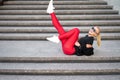 Modern collection. Fashionable handsome smiling girl in stylish sunglasses wearing black shirt, red leggings and trendy white Royalty Free Stock Photo