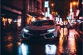 Modern Sports car on a wet street road speeding racing fast