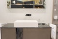 Modern square washbasin with tap mounted to wall under the mirror Royalty Free Stock Photo