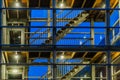 Modern staircase building with glass windows, lighted at night, apartment complex