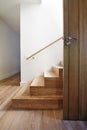 Modern staircase of oak wood beside front door Royalty Free Stock Photo