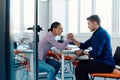 In a modern startup office, a businessman and a businesswoman business colleagues engage in a symbolic arm-wrestling