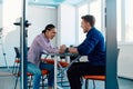 In a modern startup office, a businessman and a businesswoman business colleagues engage in a symbolic arm-wrestling