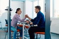 In a modern startup office, a businessman and a businesswoman business colleagues engage in a symbolic arm-wrestling
