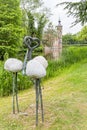 A modern statue of three flamingos with in the background the beautiful Castle Bouvigne near Breda, Netherlands