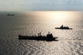Modern stealth frigate and fleet replenishment vessel sail in the sea for maritime security activity