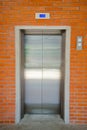 Modern steel door elevator and orange brick wall Royalty Free Stock Photo